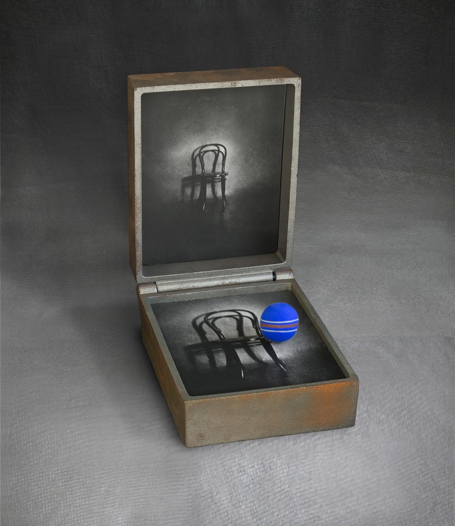 A chair.  Cast iron, image, hand-made paper, pigment. 30 x 20 x 28 cm