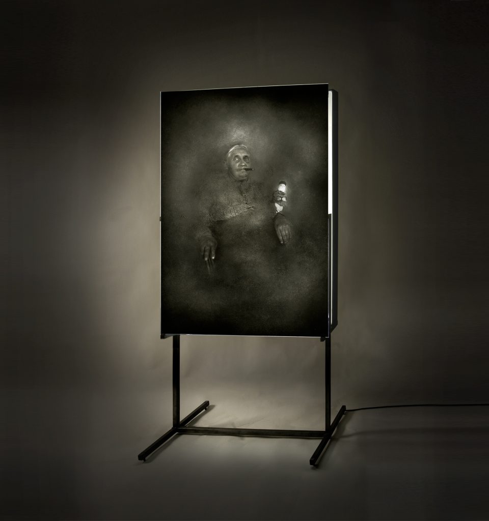 Donna con sigaro. Emulsion on glass, light, iron. 225 x 110 x 60 cm