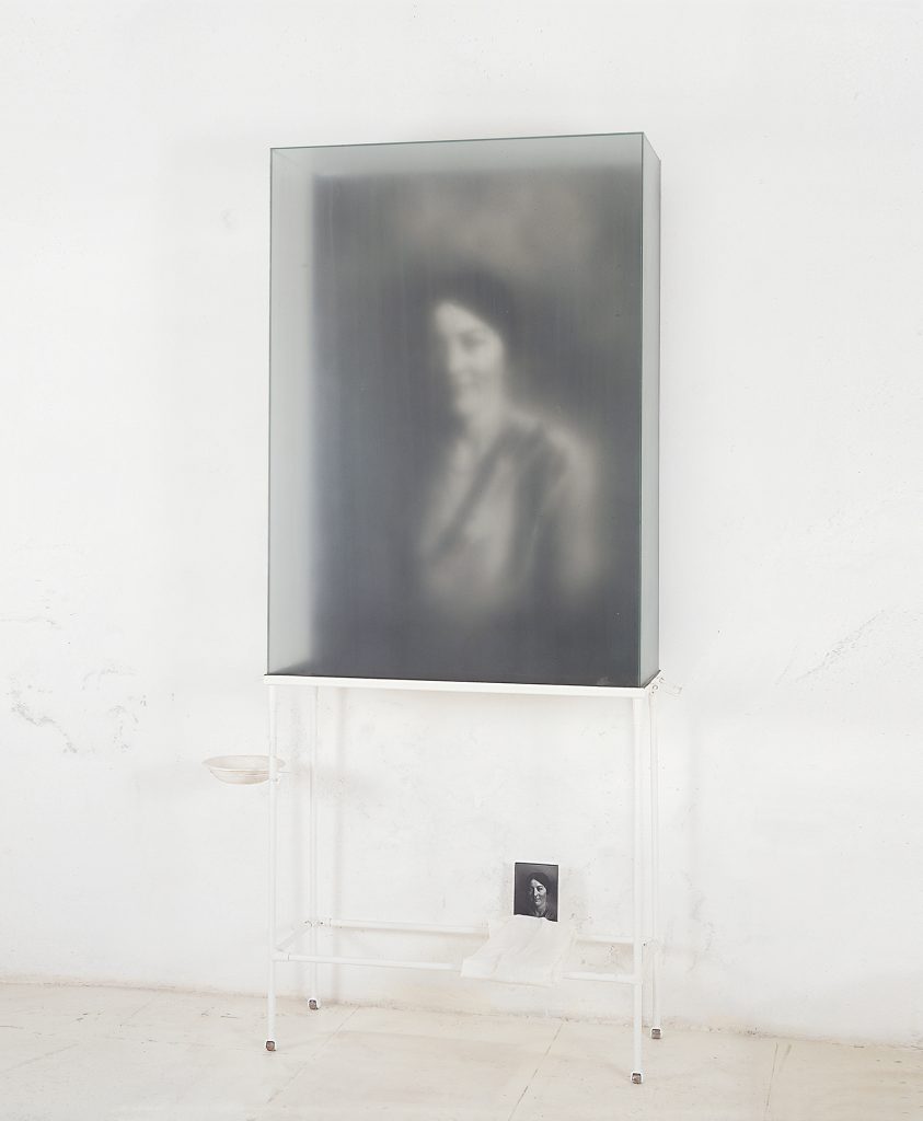 Untitled. Macrodevelopment of photographic image, iron, glass, pigment, hand made paper, white cloth. 206 x 105 x 33 cm